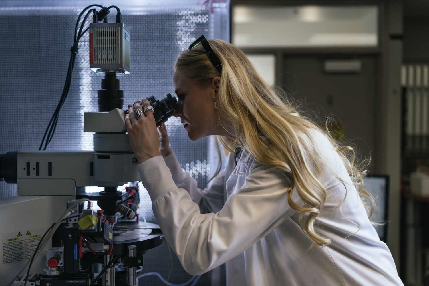 Annie Goettemoeller looks through a microscope in her lab.